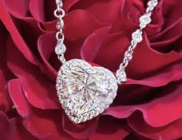 El romance de la joyería muestra un corazón de diamantes sobre un lecho de rosas rojas