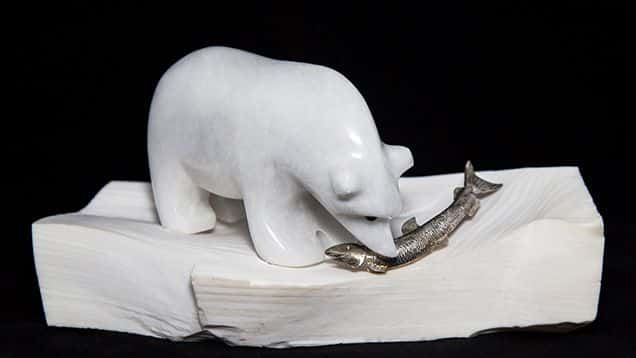 Un marco de madera de ópalo petrificado sostiene el oso polar de mármol.
