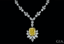 Un gran colgante de diamantes amarillos de talla cojín está parcialmente engastado con diamantes de talla marqués y cuelga de un collar de diamantes de talla mixta.
