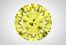 Vista frontal de un diamante brillante redondo verde-amarillo.